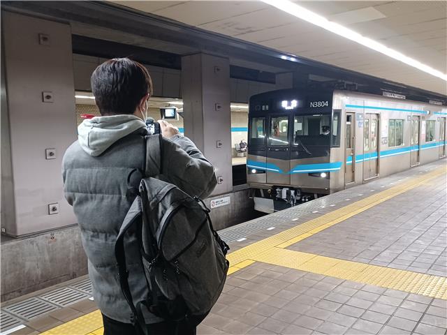 ホームから鶴舞線車両を撮影する様子